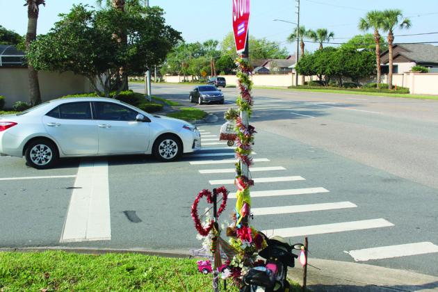 Residents coming from Barefoot Path — where a memorial sits to honor a past traffic fatality — face a slightly limited sight line due to a curve in Polynesian Isle Boulevard in Osceola County. PHOTO/KEN JACKSON