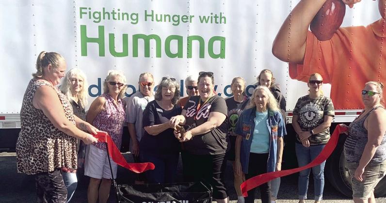 Pantry Planters’ Tammi Madison (fifth from left) helps cut the ribbon Friday on Holopaw’s community pantry. SUBMITTED PHOTO