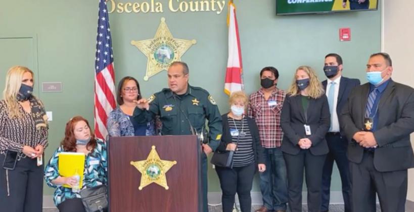 Osceola Sheriff Marcos Lopez, center, stands at the podium with Carmen Hernandez-Zengotita, left, during a press conference. PHOTO/FACEBOOK