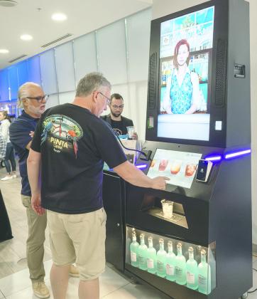 Customers order drinks from Central Florida’s first AI bartender, Sara, at the Wyndham Resort and Conference Center/Celebration last Wednesday. PHOTO/MARIO CASAMALHUAPA