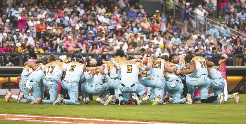 Players from the Loco Coconuts and Party Animals gathered to pray before Friday’s Banana Ball game. (Photo/ Taylor McFee)