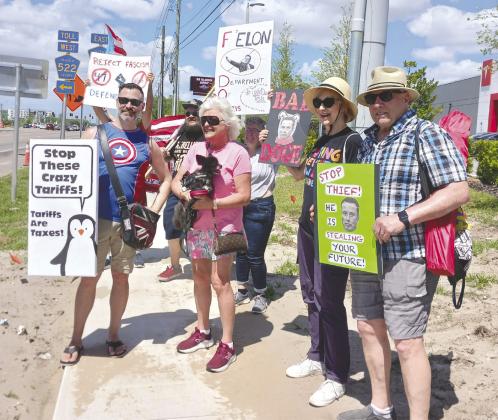 Protesters show their disdain for Tesla owner Elon Musk at a demonstration Saturday at the Kissimmee sales center. PHOTOS/LARRY GRIFFIN