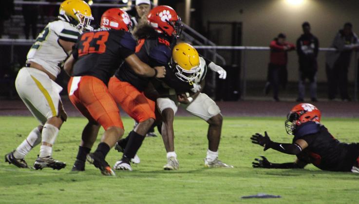 Tohopekaliga‘s Elias Fernandez (52) and Juan Gonzalez (33) wrap up Liberty quarterback Jeremiah Pierre-Louis in the Tigers’ 49-0 win Friday. PHOTO/LINDSEY TELLEZ