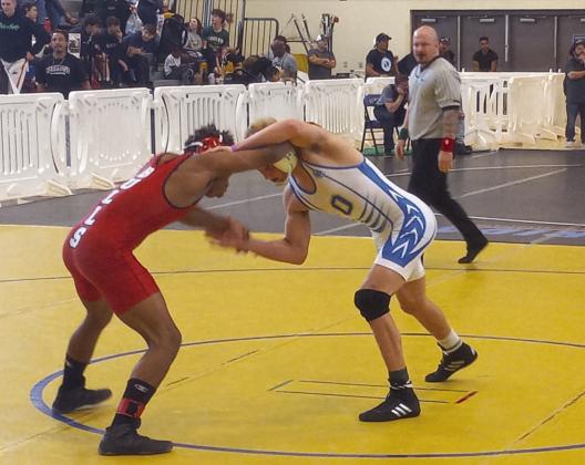 Osceola’s Anderson Heap controls Bloomingdale’s Jose Milford (red singlet) during the 142-pound final.Heap won 9-3 and will be seeking his second FHSAA state championship this weekend. PHOTO/J. DANIEL PEARSON