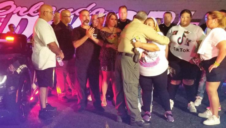 Top right: Osceola County Sheriff Marco Lopez shares a hug with Grace Cruz, the mother of Greyshalis Flores, who died in a street racing accident in Osceola County April 2, at Take it To the Track on Oct. 14. PHOTO/KEN JACKSON