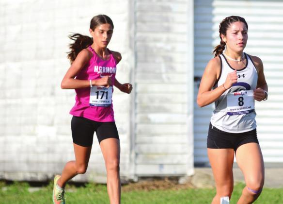 Catalina Edwards (chased by Harmony’s Lailana Decker) won OBC cross country PHOTO/DONALD LAMB