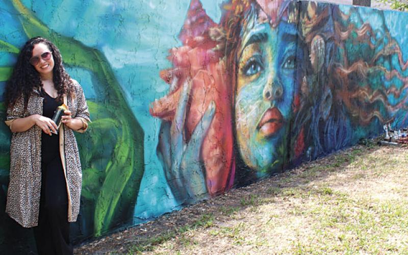 Artists Jennifer Veal (pictured), Gabriella Shepherd, Eric “The Wise Knight” Wise, and Mike “2Esae” Baca collaborated on 180 feet of wall mural adjacent to The Transition House in Kissimmee in the latest installment of Osceola Arts’ ARTisNOW public works project. (Photos/Ken Jackson)