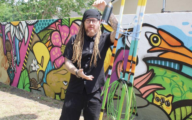 Artists Jennifer Veal, Gabriella Shepherd, Eric “The Wise Knight” Wise, and Mike “2Esae” Baca (pictured) collaborated on 180 feet of wall mural adjacent to The Transition House in Kissimmee in the latest installment of Osceola Arts’ ARTisNOW public works project. (Photos/Ken Jackson)