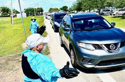 The line of cars waiting to get food stretches down the road. NEWS-GAZETTE PHOTO/BRIAN MCBRIDE