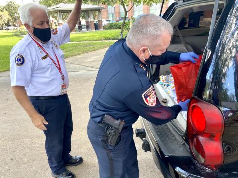 Kissimmee Police Chief Jeff O'Dell puts a bag of food in the back of a vehicle. NEWS-GAZETTE PHOTO/BRIAN MCBRIDE