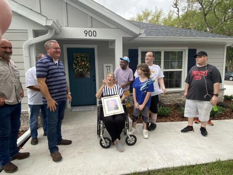 OSCEOLA NEWS-GAZETTE/Gail Foster and her children in front of their new home with the supporters who helped them rebuild, including members of the St. Cloud Fire Department. 