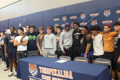 Tohopekaliga students gathered Thursday as Cameron Selfe (front, in grey at left) and Kam Davis-Roberts signed to play college football. PHOTO/KEN JACKSON
