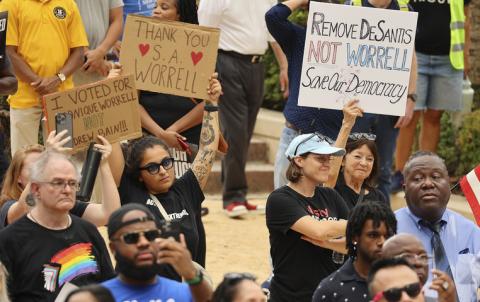 Monique Worrell's supporters hold signs at her press conference announcing her removal from office by Gov. Ron DeSantis on Aug. 9. FACEBOOK