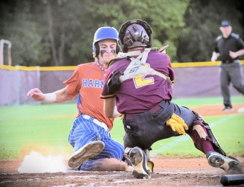 Harmony's Nate O'Neill slides into home as St. Cloud catch Josh Bejarano attempts to apply the tag in Friday's 11-1 Longhorn win in the OBC championship game. PHOTO/KATIE WILLIAMS 