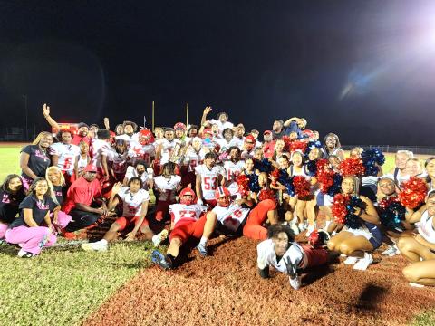 Players, coaches and cheerleaders gather with the Orange-Osceola Challenge Classic trophy after their 35-14 win. PHOTO/KEN JACKSON