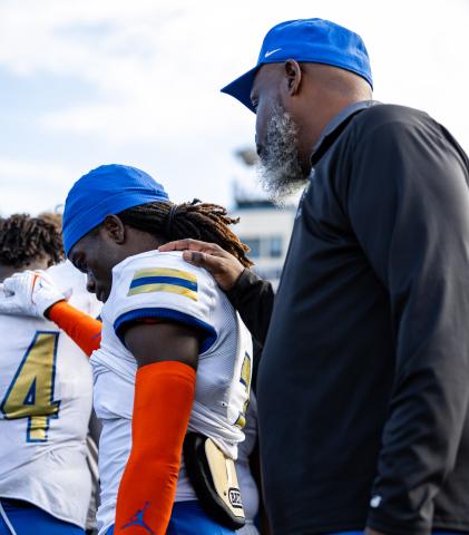 Osceola assistant coach and former Kowboy Chad Mascoe consoles Jakyri Watson following Friday's 26-7 loss to West Boca Raton in the Class 6A championship game. PHOTO/TAYLOR MCFEE 