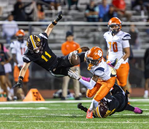 "Hit 'em low, hit 'em high": St. Cloud linebacker Chase Gilbert (11) takes to the air and Bryce Williams (5) goes to the ground to bring down Tohopekaliga's Tre Punter in Friday's 44-21 Bulldogs win. (Photo/Taylor McFee)