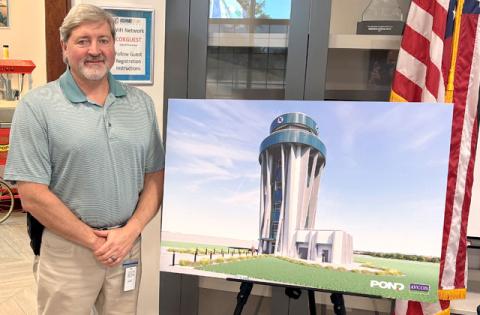 Shaun Germolus, Director of Aviation for the City of Kissimmee, with an architectural rendering of the proposed new air traffic control tower, which would be located at the end of Patrick Street. (Photo/Terry Lloyd)