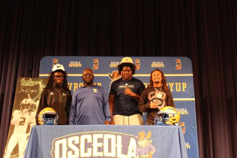 From left, Osceola High's Jakyri Watson, Amier Clarke and Alijah Jenkins signed their college football scholarships Wednesday, as OHS Coach Eric Pinellas looked on. (Photo/Ken Jackson) 