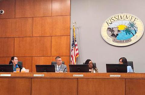 Kissimmee City Attorney Olga Sanchez de Fuentes (far left) and Mayor Jackie Espinosa (far right) discuss the reasoning behind the mayor's motion to terminate the attorney prior to the vote at Monday's Commission meeting. (Photo/Ken Jackson)
