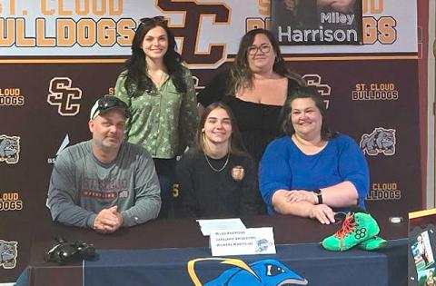 Surrounded by family, Miley Harrison (center) signs her letter-of-intent to wrestle at Lakeland College in Wisconsin. (Photo/Mike Short)