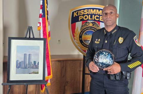 Kissimmee Police Chief Chuck Broadway, a New York Police Department detective on Sept. 11, 2001, with reminders of 9/11: a photo of the World Trade Center “Twin Towers” and a 25th anniversary plate. (Photo/Ken Jackson)