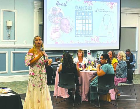 United In Love Adoptions founder and Agency Attorney Barbara “BJ” Harris kicks off the first Bingo game Saturday for a designer purse prize. (Photo/Terry Lloyd)