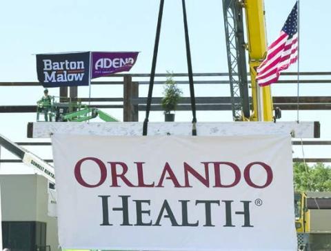 A structural I-beam signed by hospital leaders and medical team members is hoisted into place Thursday to complete the connection to the new section of the hospital. (Photo/Terry Lloyd)