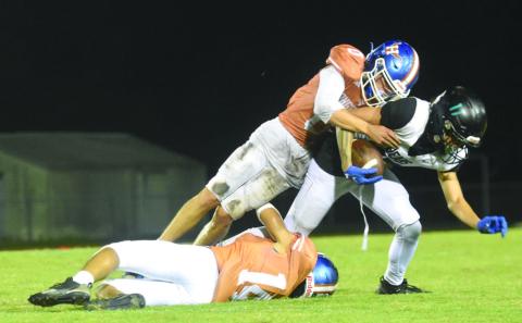 Harmony defenders Chase Adams (0) and Jaylen Carr (14) team up to take down Bayside’s Jaylen Miranda in the Longhorns’ 17-7 Friday. Harmony heads to Lake Howell this week to go for the winning streak. PHOTO/KATIE WILLIAMS