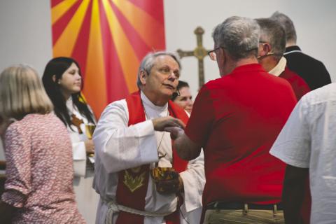 The Rev. Rob Cosmas serves communion at the 65th anniversary service at Trinity Lutheran Church in Kissimmee. (Submitted photo)